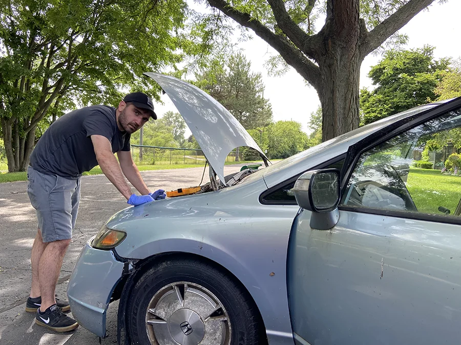 An annoyed man working on a car